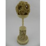 A Chinese ivory puzzle ball, raised on a reticulated stand. H.