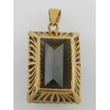 A yellow metal and smoky quartz pendant.