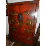 A Chinese scarlett laquered hall cupboard, painted with pagodas and figures in landscape,