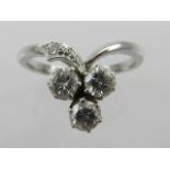 An unusual white metal and three stone diamond cluster ring, set three stones of approx. 0.