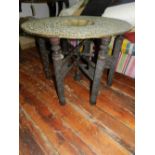 A Moroccan brass tray top table, on a pierced hardwood stand.