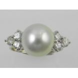 An 18 carat white gold, pearl, and diamond set ring,