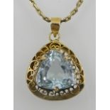 A yellow metal mounted trillion cut aquamarine pendant, the suspension loop stamped 18K,