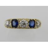 A yellow metal, diamond and sapphire ring, set five graduated stones, the diamonds of approx. 0.