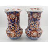 A pair of Japanese imari vases, having flared rim and decorated with flowers and prunus. H.