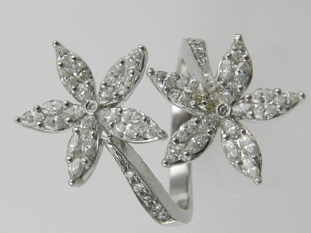 A platinum and diamond double flowerhead crossover design ring,