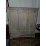 A lined oak wardrobe, having two cupboard doors over two long drawers, and one side cupboard door.