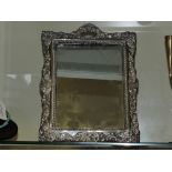 An Edwardian silver easel dressing table mirror embossed with a vacant cartouche,