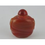 A red veined hardstone snuff bottle, with a clear red knop.