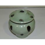 A celadon glazed lidded pot, of squat baluster form, with dashes of brown glaze, H. 9cm.