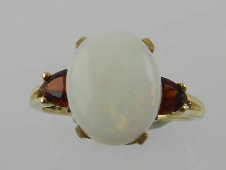 A 9 carat yellow gold, opal, and garnet ring.