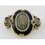 A Victorian gold and enamel Momento Mori brooch, set central reserve with curl of hair,