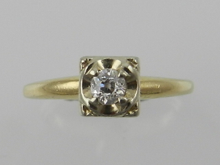 A yellow metal and diamond ring, set single stone, the shank stamped 14K.