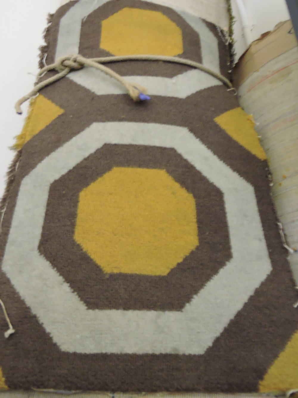 Two rolls of 1970s gold/ivory/brown carpet woven with rows of octagonal motifs,