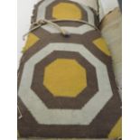 Two rolls of 1970s gold/ivory/brown carpet woven with rows of octagonal motifs,