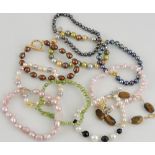 Ten assorted multi coloured pearl bracelets, some with silver clasps.