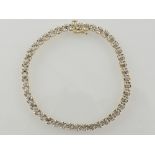 A diamond set bracelet in yellow metal stamped 10K, 5.5g.