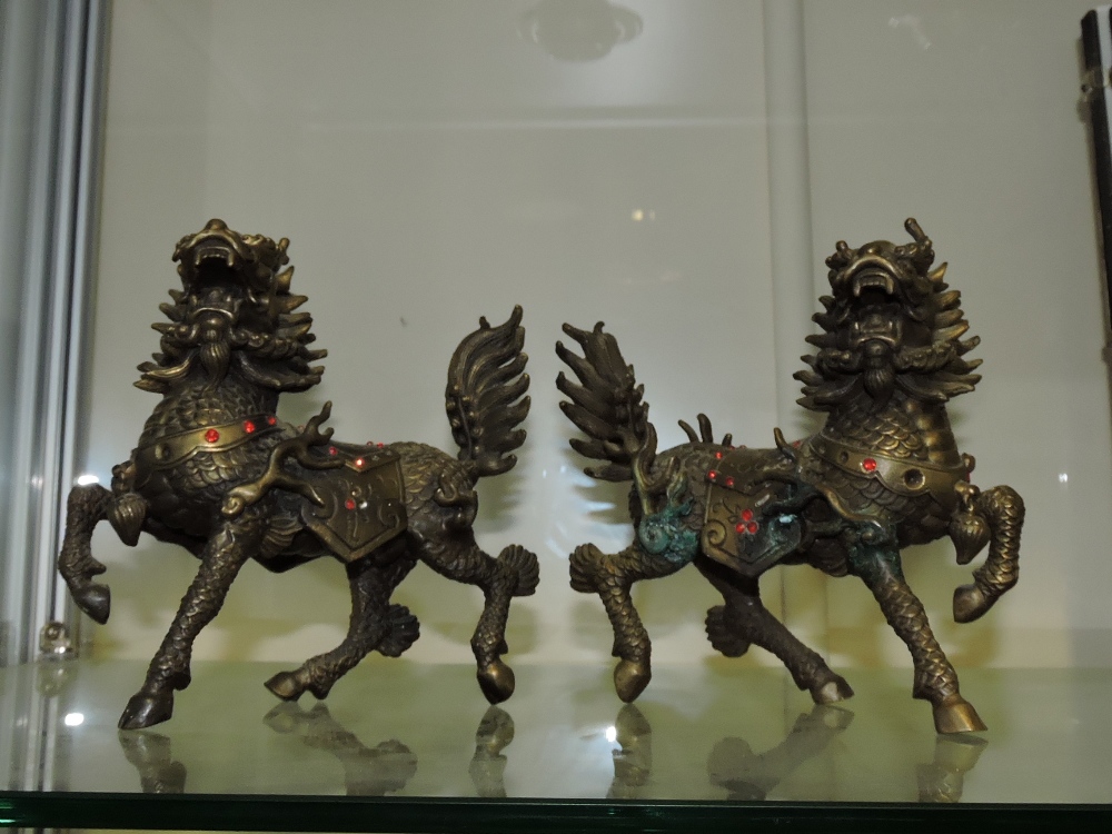 A pair of ornately cast Chinese bronze Shi-Fu lion dogs.