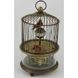 A table clock in the form of a caged birds, H. 17cm.