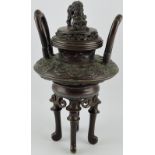 A late 19th century bronze koro, with dragon knop, pierced lid and extended loop handles,