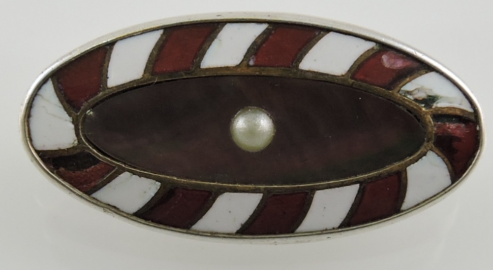 A silver enamel, mother-of-pearl and pearl set brooch, oval with a red and white striped border, 4.