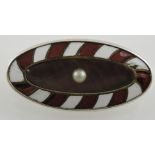 A silver enamel, mother-of-pearl and pearl set brooch, oval with a red and white striped border, 4.