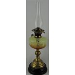 A Victorian oil lamp, the yellow glass reservoir on a turned foliate brass support, H. 85cm.