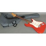 An Encore electric guitar, with rosewood fingerboard and red lacquer body, with strap and soft case.