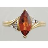 A garnet and diamond set dress ring, the navette cut stone on a yellow metal band, 3.5g.