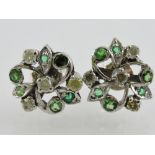 A pair of green garnet and diamond set floral ear studs, set in white metal, 2g.