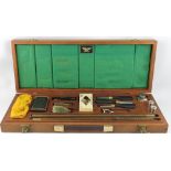A shotgun cleaning kit, including 12-bore dummy cartridges, within a fitted mahogany case,