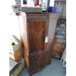 Serpentine front mahogany drinks cabinet with double doors above a single drawer and two smaller