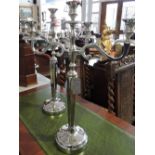 A pair of Victorian style plated three branch candelabra on circular bases.