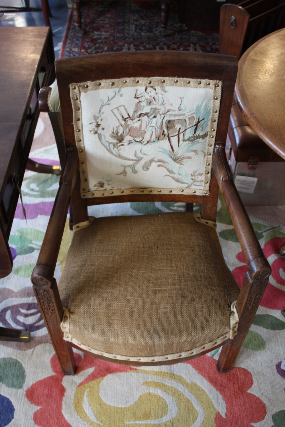 A 19th Century French provincial empire style walnut elbow chair with anthemion carved frame on