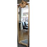 A Victorian style gilt framed tall pier glass with C scroll pediment and fluted frame. H. 208cm.