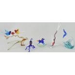 A collection of glass animals including birds on a branch, octopus and rocking horse.