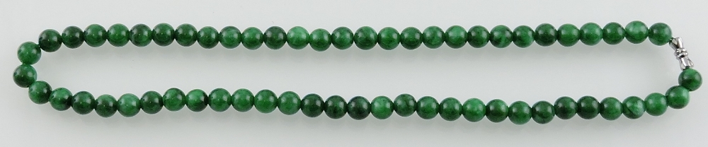 A jade necklace, of uniform beads, L. 44cm.