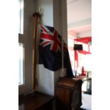 A vintage mahogany boat stern flagpole with naval ensign.