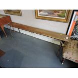 A 1950s French pine school bench on tubular metal underframe, L. 182cm.