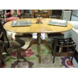 A Victorian style circular oak extending dining table on turned baluster pillar and quadruple