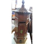A Victorian style mahogany internal postbox of hexagonal pillerbox form with carved acanthus canopy,