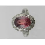 A platinum, ruby and diamond cluster ring, set large central stone surrounded by small diamonds,