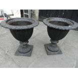 A pair of cast metal campana urns. H.