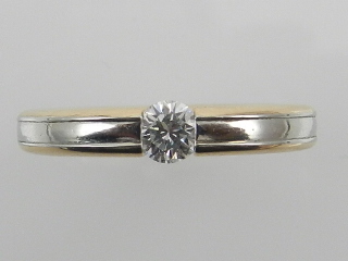 An unusual white and yellow metal and diamond ring, tension set single diamond of approx. 0.
