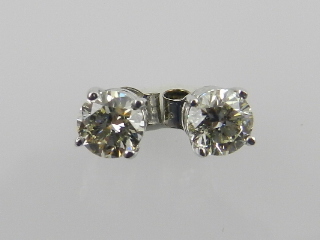 A pair of 14ct white gold solitaire diamond ear studs, total weight 1.08ct.