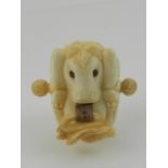 A carved bone novelty tape measure in the form of a horse eating hay.