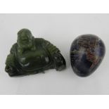 A green jadeite figure of Buddha, together with a hardstone egg decorated as the globe.