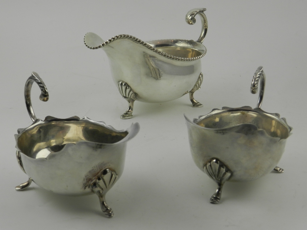 A silver plated sauce boats, raised on three feet,