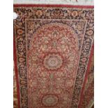 A Persian Kashan red ground runner, having three medallion to centre on a floral ground, multi-