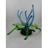 A six branch glass table light, having green and blue tentacle shaped arms.